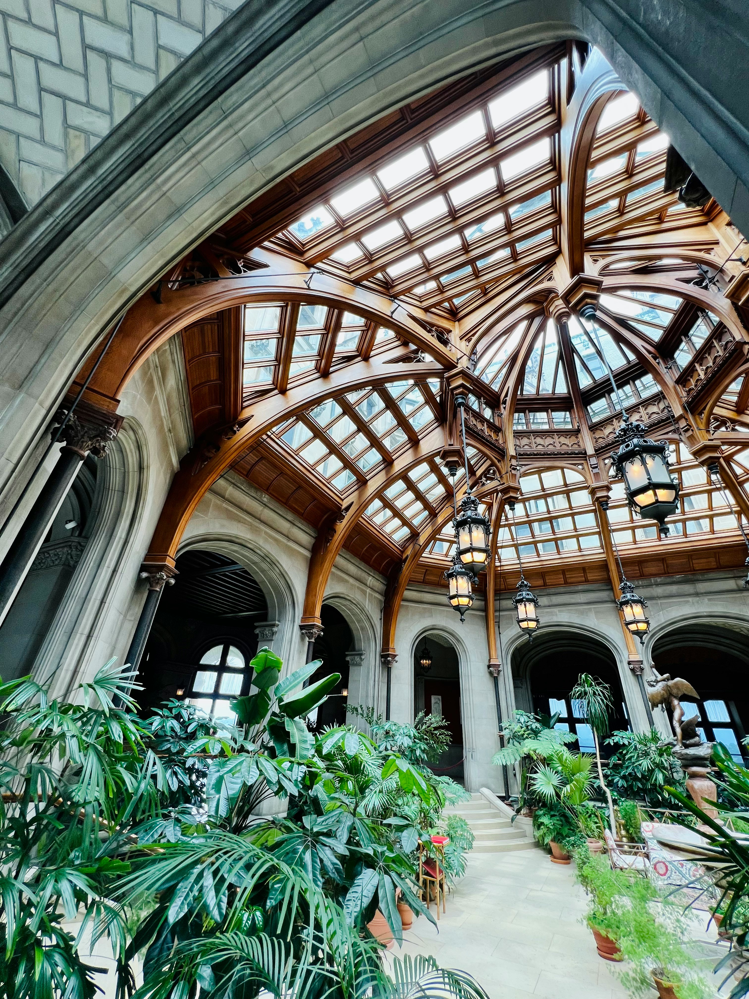 Biltmore Estate conservatory with sky lights, greenery, and Christmas garlands.